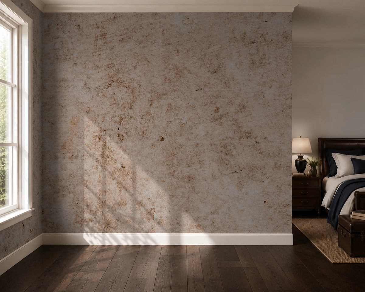 A textured beige and brown distressed industrial wall mural or wallpaper shown in a styled bedroom setting with dark wood floors, a window, and a bed.