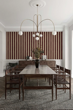 Dining room with a long table and chairs against a striped wallpaper.