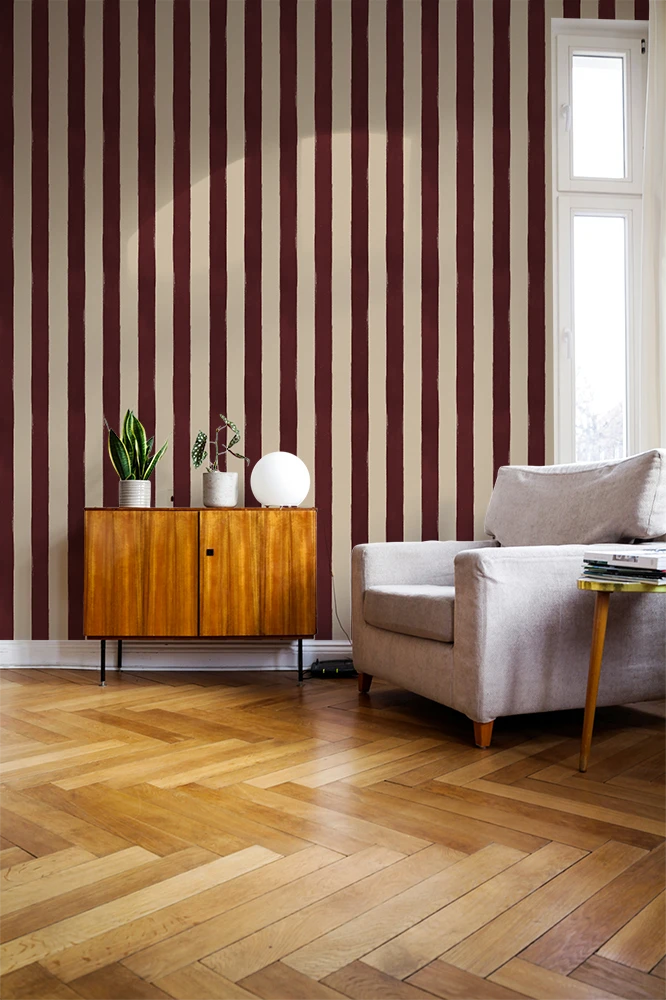 Living room with striped red wallpaper, wooden floor, and furniture.