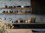 Modern kitchen with floral wallpaper and wooden shelves.
