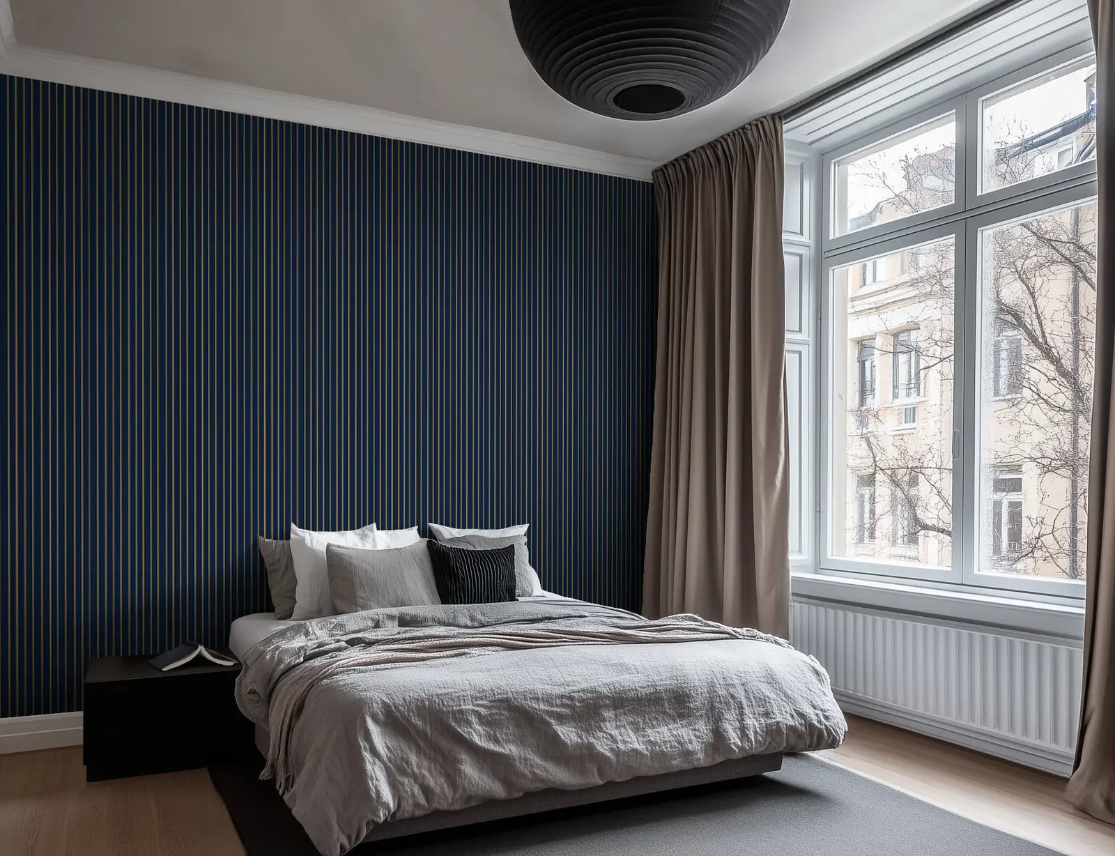 Scandinavian styled bedroom with navy and gold striped wallpaper.  