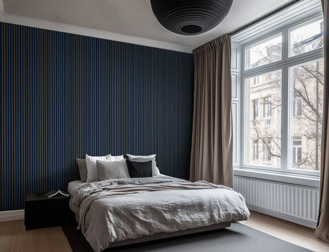 Scandinavian styled bedroom with navy and gold striped wallpaper.  