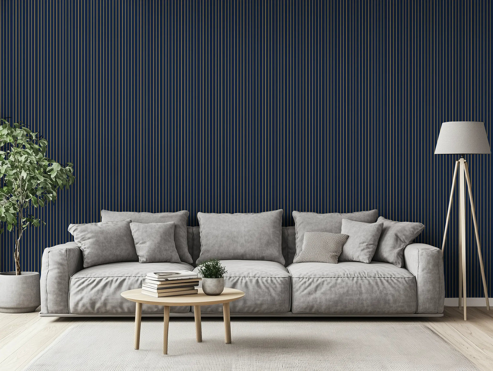 Modern living room with striped gold and navy wallpaper, a grey sofa, a lamp, and a plant. 