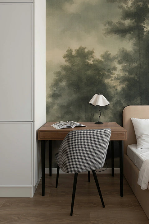 Small desk with chair against a wall with nature-themed wallpaper forest mural.