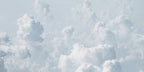 Wallpaper mural from a photograph, showing big white clouds across a sunny sky. 
