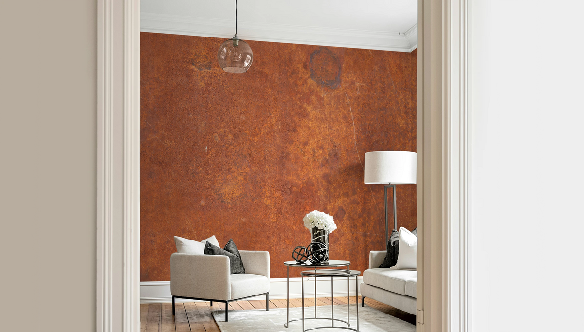 Modern living room with a white arm chair, and a wallpaper mural with industrial rust texture. 