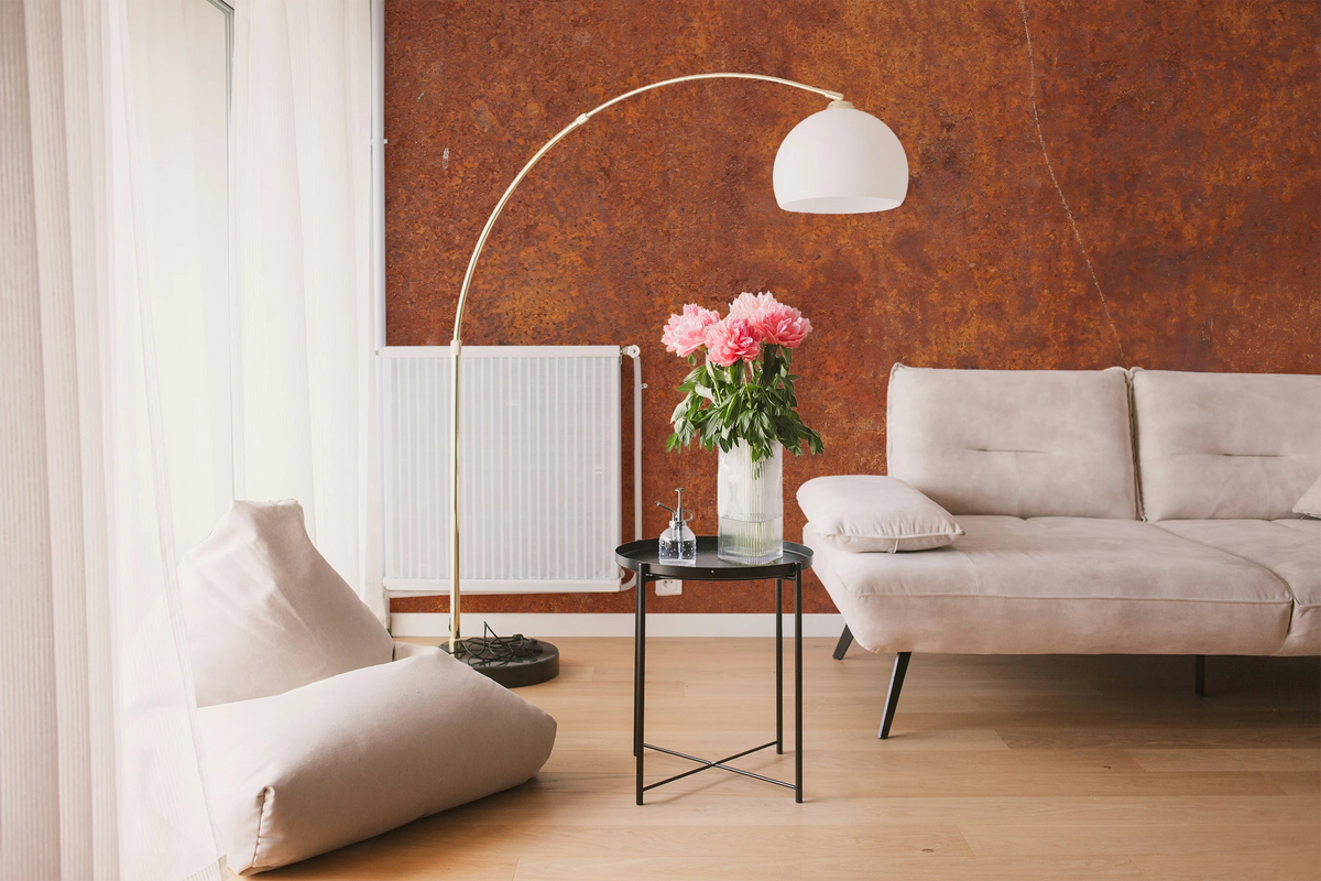 Modern living room with a white sofa, and a wallpaper mural with industrial rust texture. 