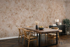 A styled dining room featuring a large, industrial-textured beige and brown wallpaper mural as the primary product, shown behind a wooden dining table and chairs.