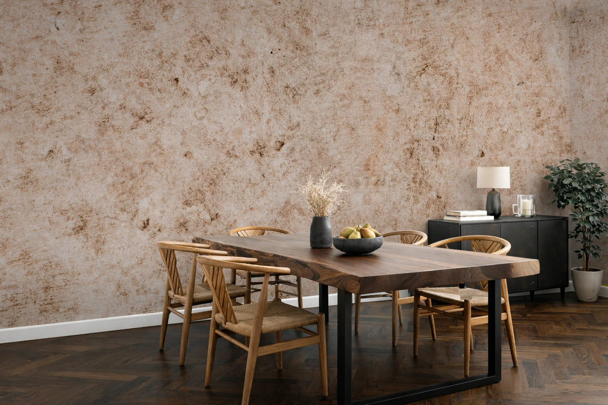 A styled dining room featuring a large, industrial-textured beige and brown wallpaper mural as the primary product, shown behind a wooden dining table and chairs.
