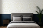 Bedroom with a bed, nightstand, and beige butterfly wallpaper pattern.