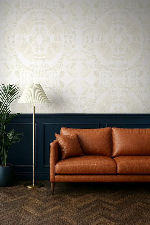 Brown leather sofa in a room with beige butterfly wallpaper pattern and a standing lamp.