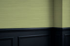Green textured grasscloth wall with black baseboard