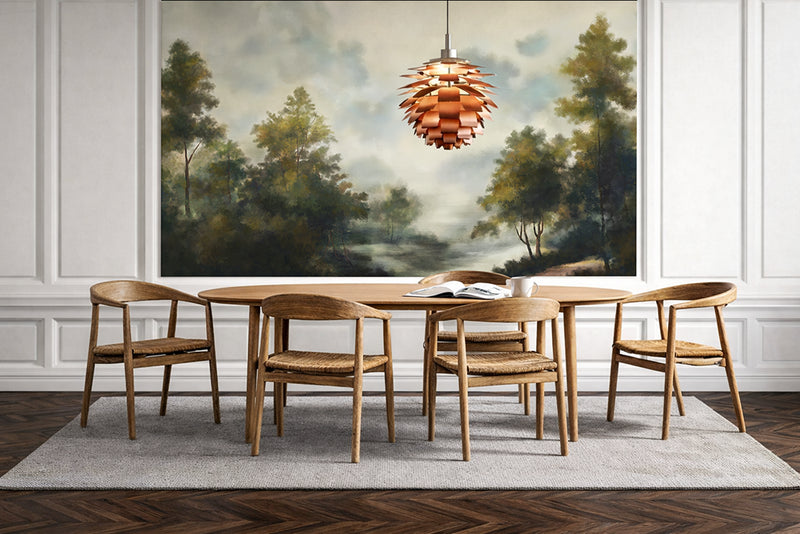 Dining room with wooden table and chairs, modern pendant light, and large vintage landscape forest wallpaper mural on the wall.