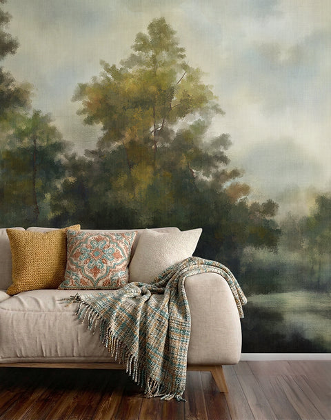 Sofa with decorative pillows and a blanket against a wallpaper forest mural.