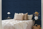 A cosy bedroom with navy blue faux grasscloth wallpaper with a rich woven texture.