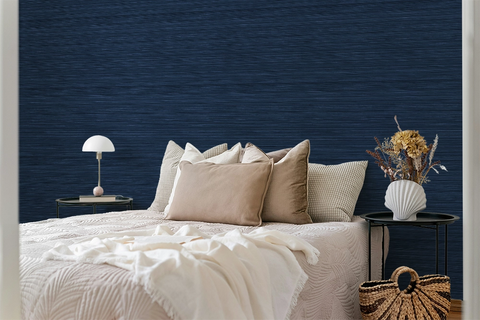 A cosy bedroom with navy blue faux grasscloth wallpaper with a rich woven texture.
