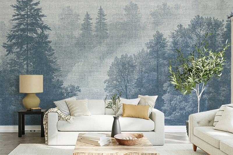 Blue forest wallpaper mural in a cozy Scandinavian living room with soft neutral furniture, textured decor, and misty Nordic trees inspired by fjord landscapes.
