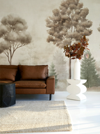 Modern living room with a leather sofa and vintage forest mural wallpaper