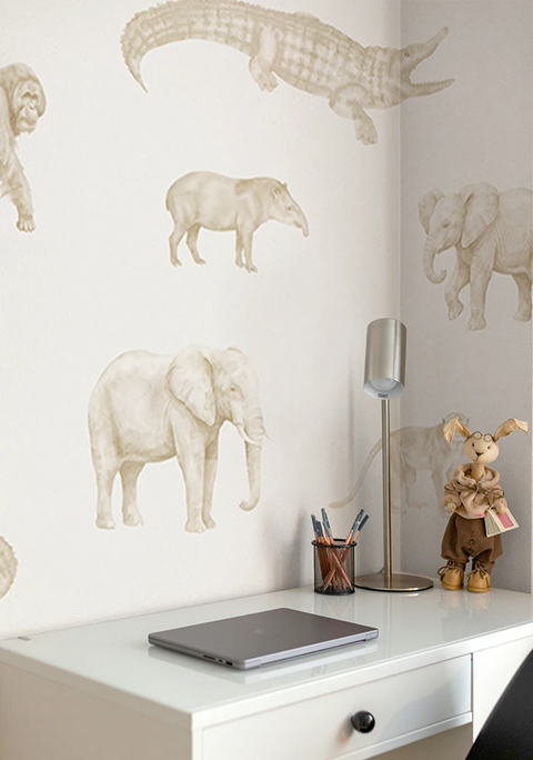 Kids wallpaper with animal prints in a room with a desk and lamp.