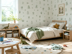 Children's bedroom with patterned aquatic wallpaper, bed, and toys.
