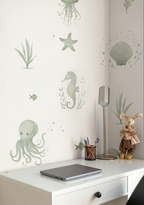 Wall with underwater-themed kids wallpaper above a desk with stationery items.
