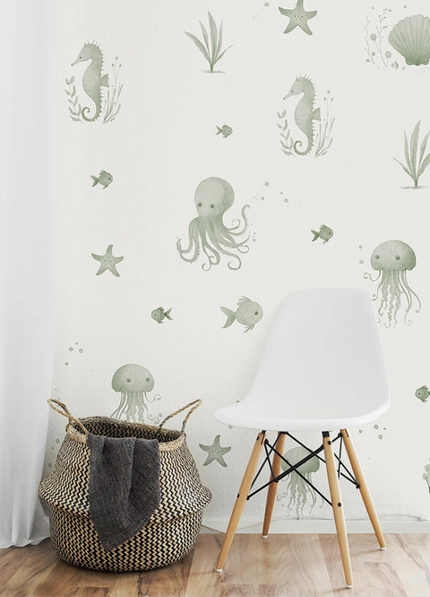 Wall with underwater-themed kids wallpaper, including seahorses, octopuses, and jellyfish, with a white chair and woven basket in the foreground.