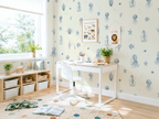 Children's room with wallpaper featuring sea creatures, desk, and toys.