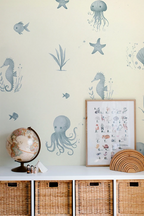 Nautical-themed room with aquatic wallpaper, decor items, and storage baskets.