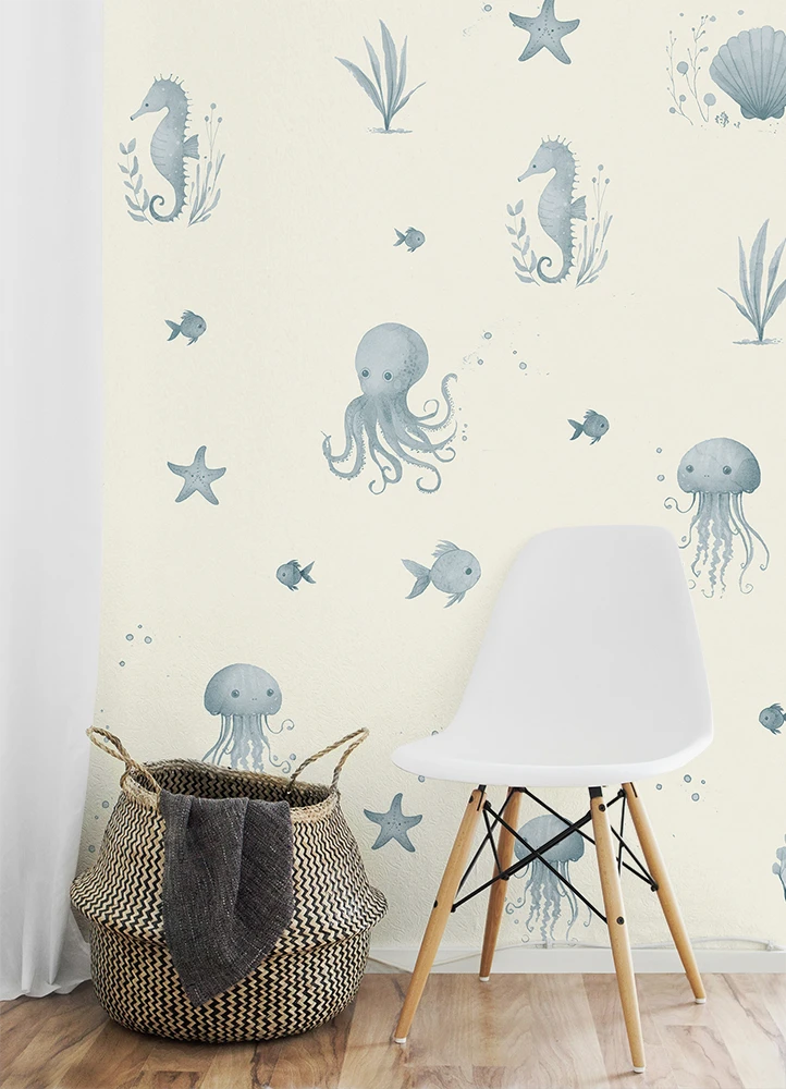 Wallpaper with marine-themed designs featuring seahorses, octopuses, and jellyfish in a room with a chair and basket.