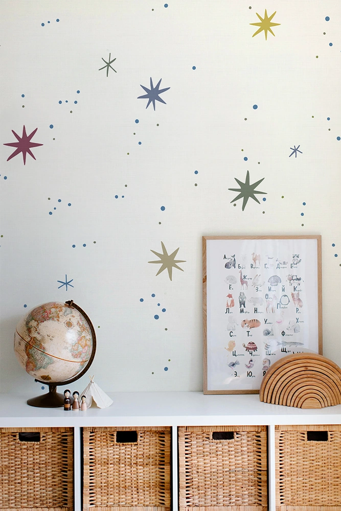 Kids room, a wall with star and planet wallpaper, framed poster, globe, and wicker baskets.