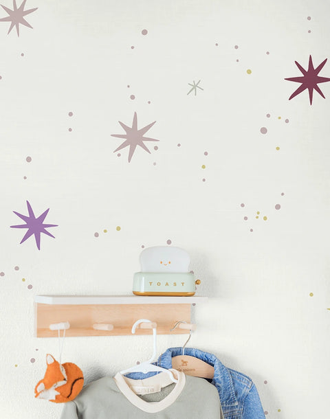 Kids star wallpaper and a coat rack with clothes and a toy on a light background