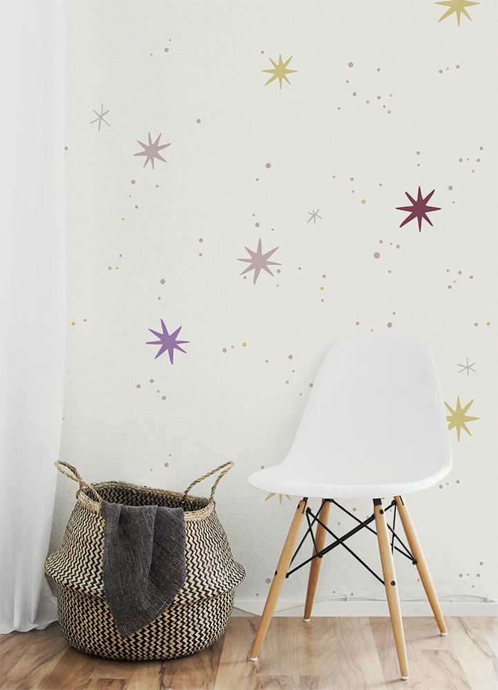 Kids room with a white chair and woven basket against a wall with star-shaped kids wallpaper