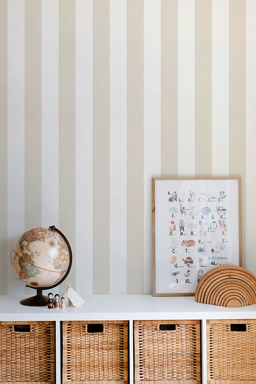Striped wallpaper with a kid's shelf featuring a globe, framed picture, and woven baskets.