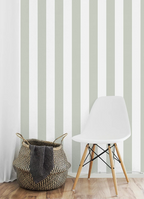 Kids room with a white chair and woven basket against a striped kids wallpaper.