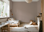 Kids room with striped terracotta kids wallpaper, wooden crib, and toys on a rug.