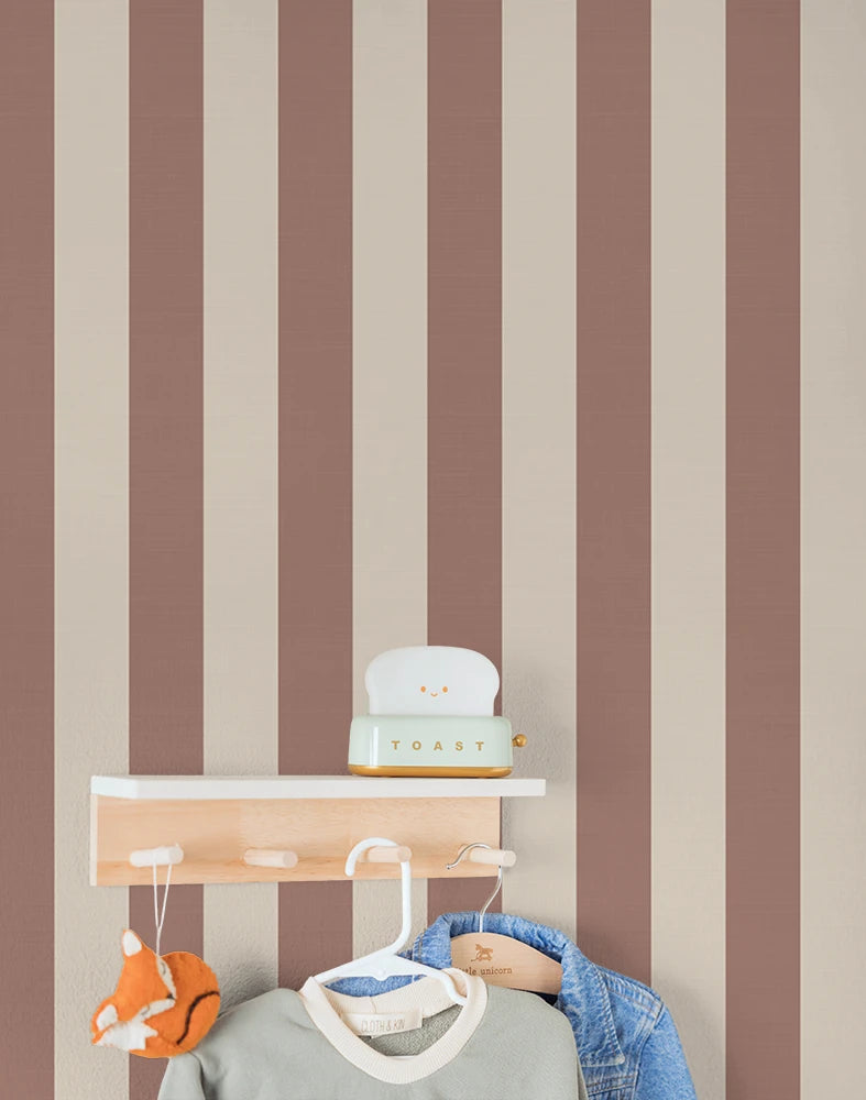 Striped terracotta kids wallpaper with a shelf, toys, and clothing against a brown and beige striped wall.