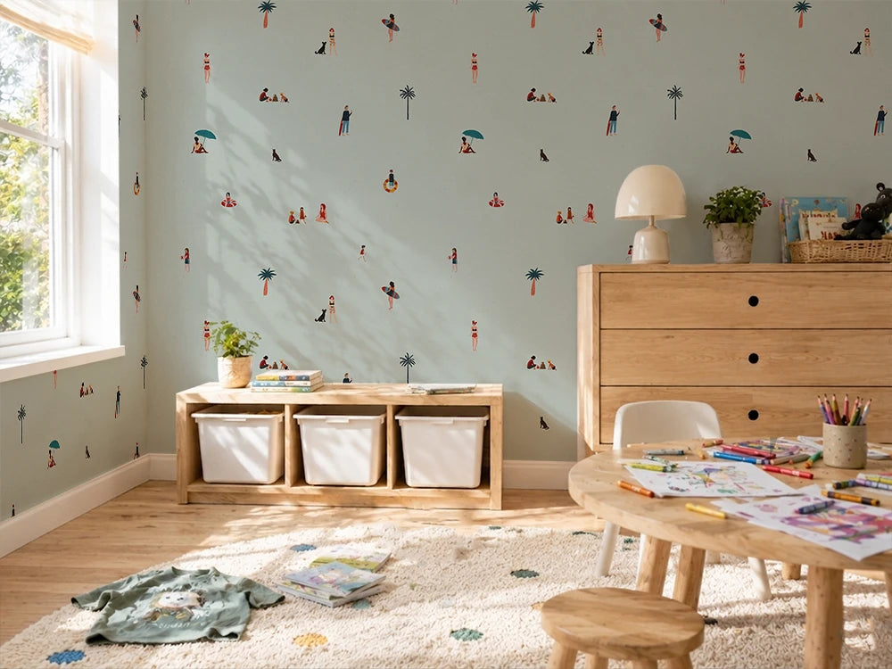 Children's room with light blue walls, wooden furniture, and colorful kids' wallpaper with people at a beach.