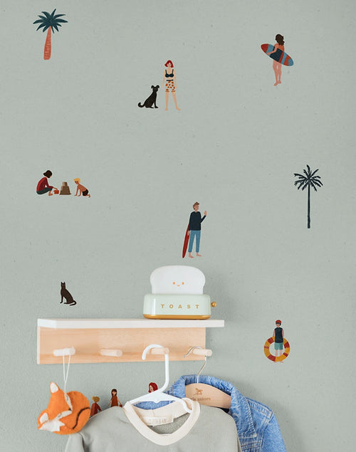 Kids wallpaper pattern with people, palm trees, and a dog on a light green background.