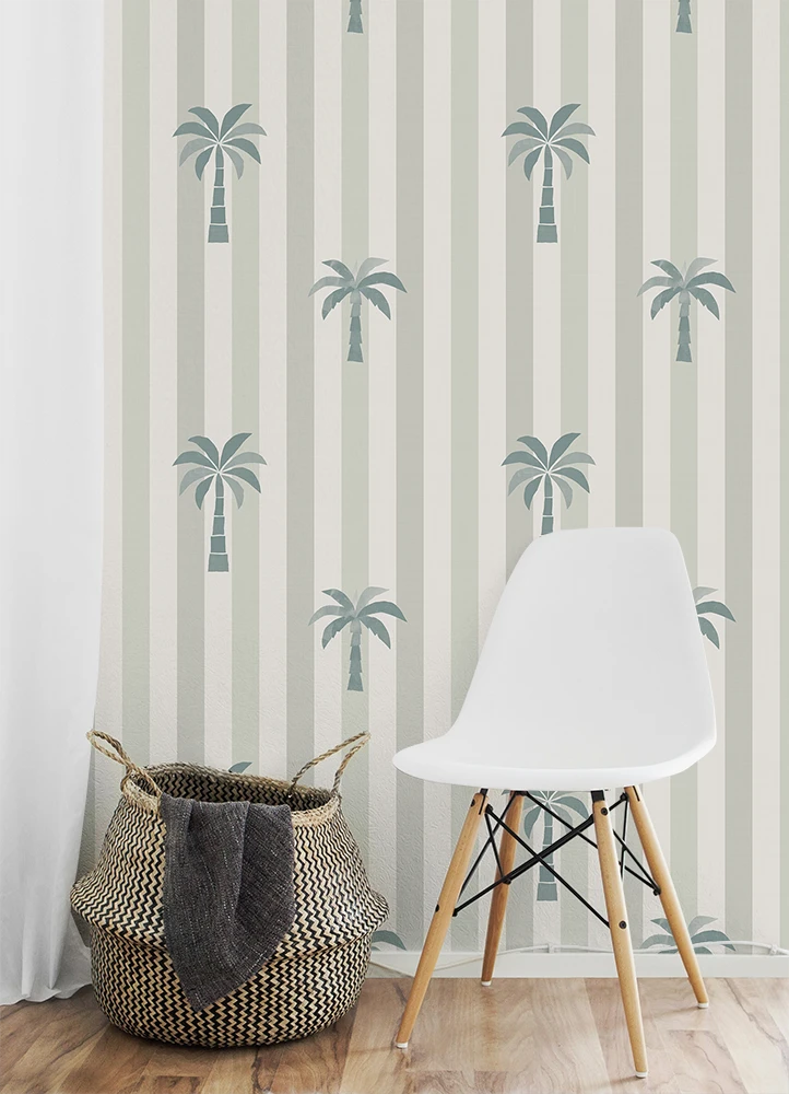 White chair and woven basket against striped wallpaper with palm tree design