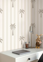 White desk with laptop, lamp, and decorative items against a wall with palm tree kids wallpaper