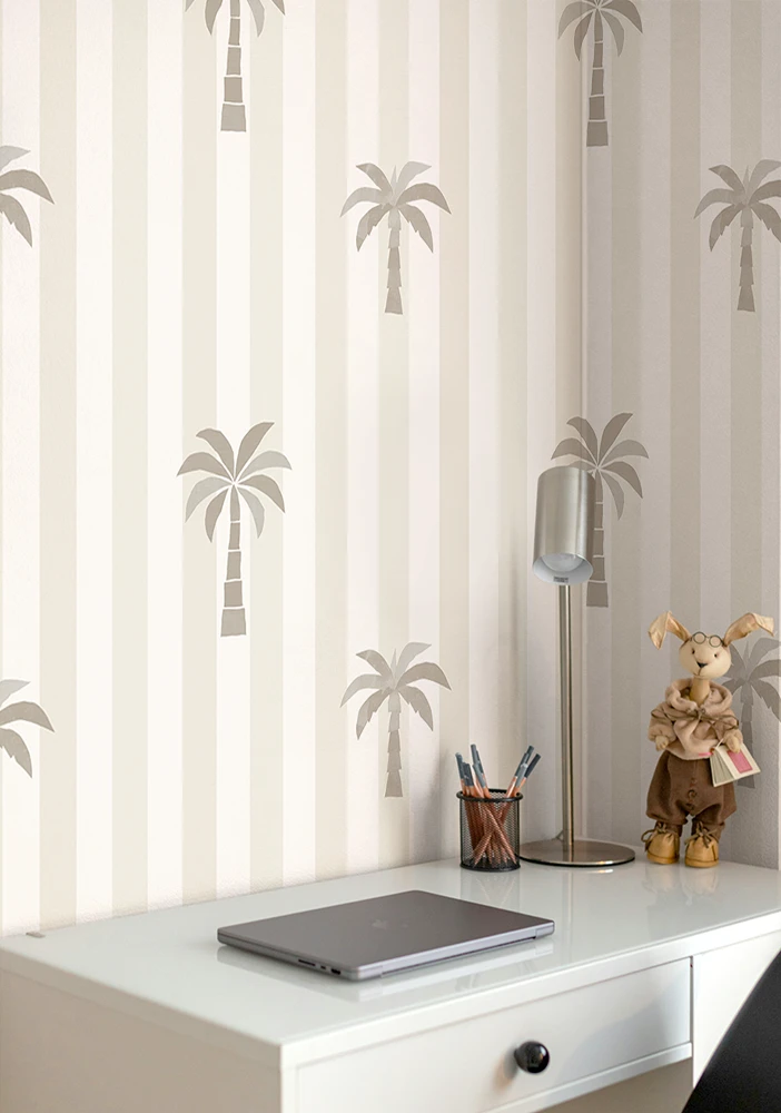 White desk with laptop, lamp, and decorative items against a wall with palm tree kids wallpaper