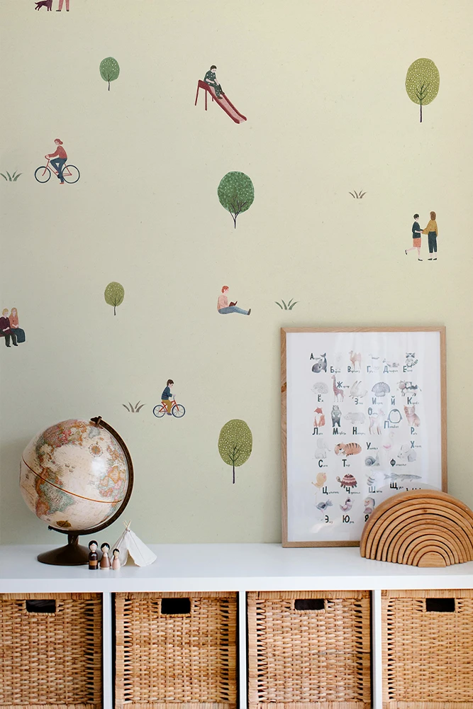 Wall with children's wallpaper, a framed picture, a globe, and wicker baskets.
