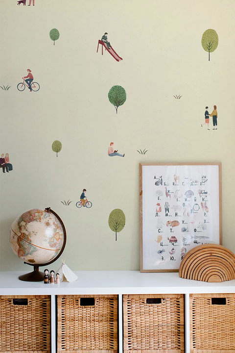 Wall with children's wallpaper, a framed picture, a globe, and wicker baskets.