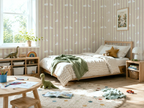 Children's bedroom with striped wallpaper, bed, and toys.