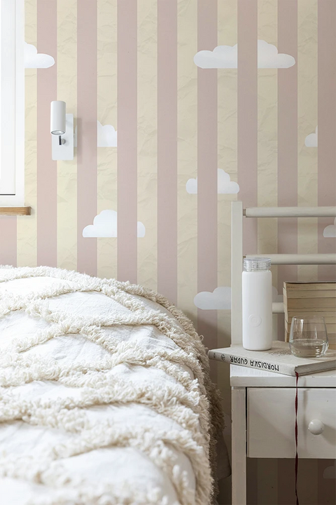 Teenager bedroom with striped wallpaper featuring white clouds, a bed with white bedding, and a nightstand.