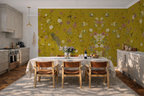 Kitchen with a dining table and chairs against a wall with chinoiserie wallpaper with a yellow background, featuring flowers and peacocks. 