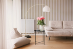 Modern living room with a beige sofa, armchair, a floor lamp and a wall with a beige striped wallpaper pattern.