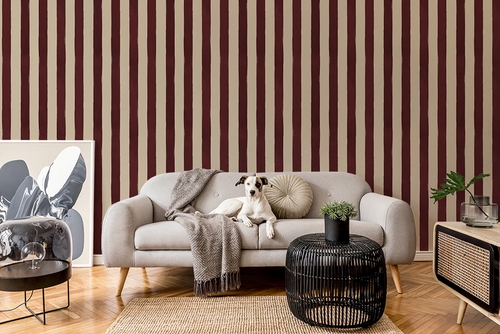 Living room with burgundy striped wallpaper, gray sofa, and decorative items.