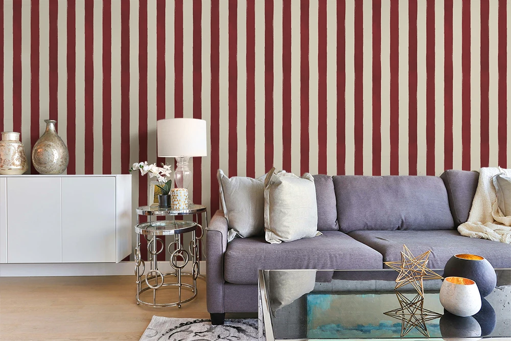 Living room with a gray sofa against a red and white striped wallpaper.