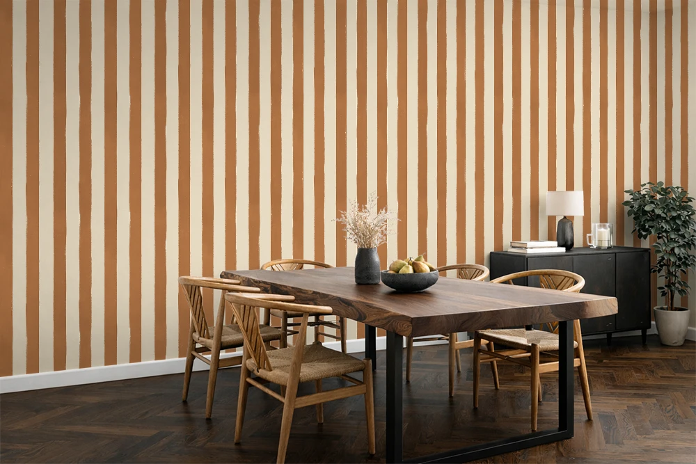 Dining room with wooden table and chairs against a caramel striped wallpaper.